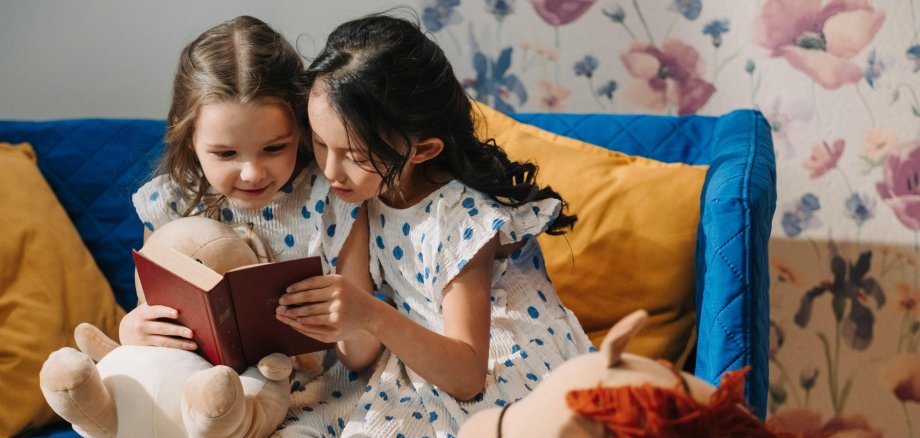 Zwei Mädchen im Grundschulalter lesen ein Buch