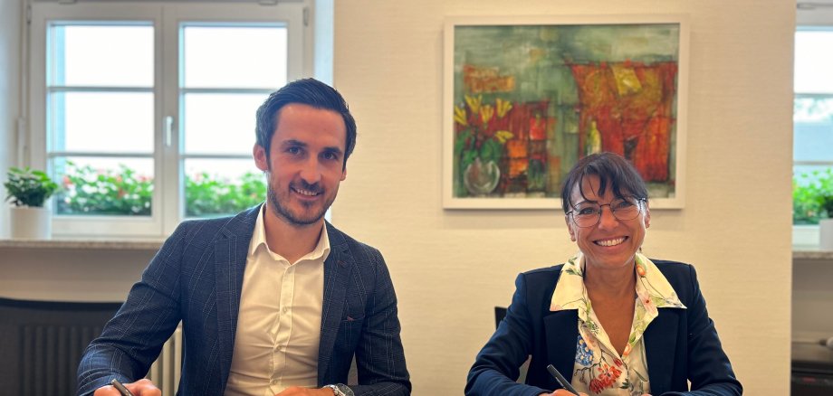 von links: Mario Bischof, Geschäftsführer i+R Industrie- & Gewerbebau, Bürgermeisterin Regine Rist, unterzeichnen den Vertrag zum Bau der Sporthalle