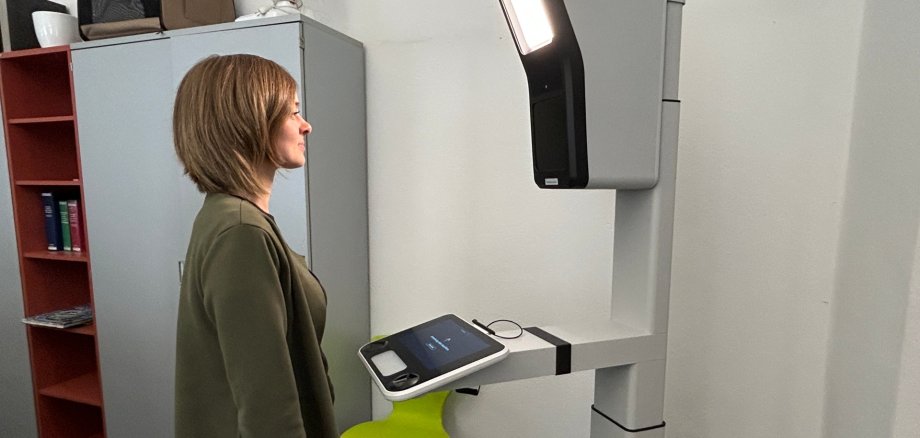 Frau stehend vor dem PointID-System zur Aufnahme von digitalen Ausweisbildern