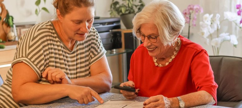 Ältere Damen wird beim Lesen unterstützt