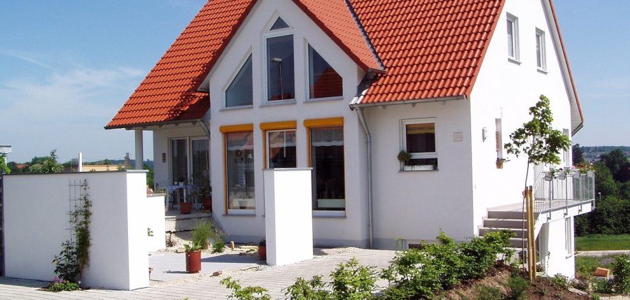 weißes Einfamilienhaus mit Garten