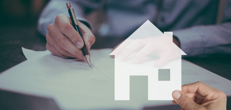 Piktogramm eines Hauses, im Hintergrund eine Hand, die etwas schriebt