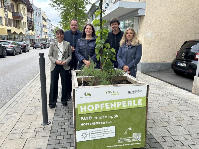 v. li: Bürgermeisterin Regine Rist, Fritz Tauscher - 1. Vorsitzender Tettnang erleben e. V., Ann Bauer - Citymanagerin Tettnang erleben e. V., Lukas Locher – Hopfengut hinter einer Hopfenkiste in der Karlstraße stehend