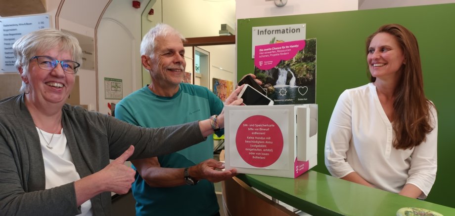 Marion Schodt und Erich Schoepe vom Technikcafe sowie Susanne Schmid von der Stadt Tettnang freuen sich über die neue Box, die ab sofort im Rathaus alte Handys sammelt