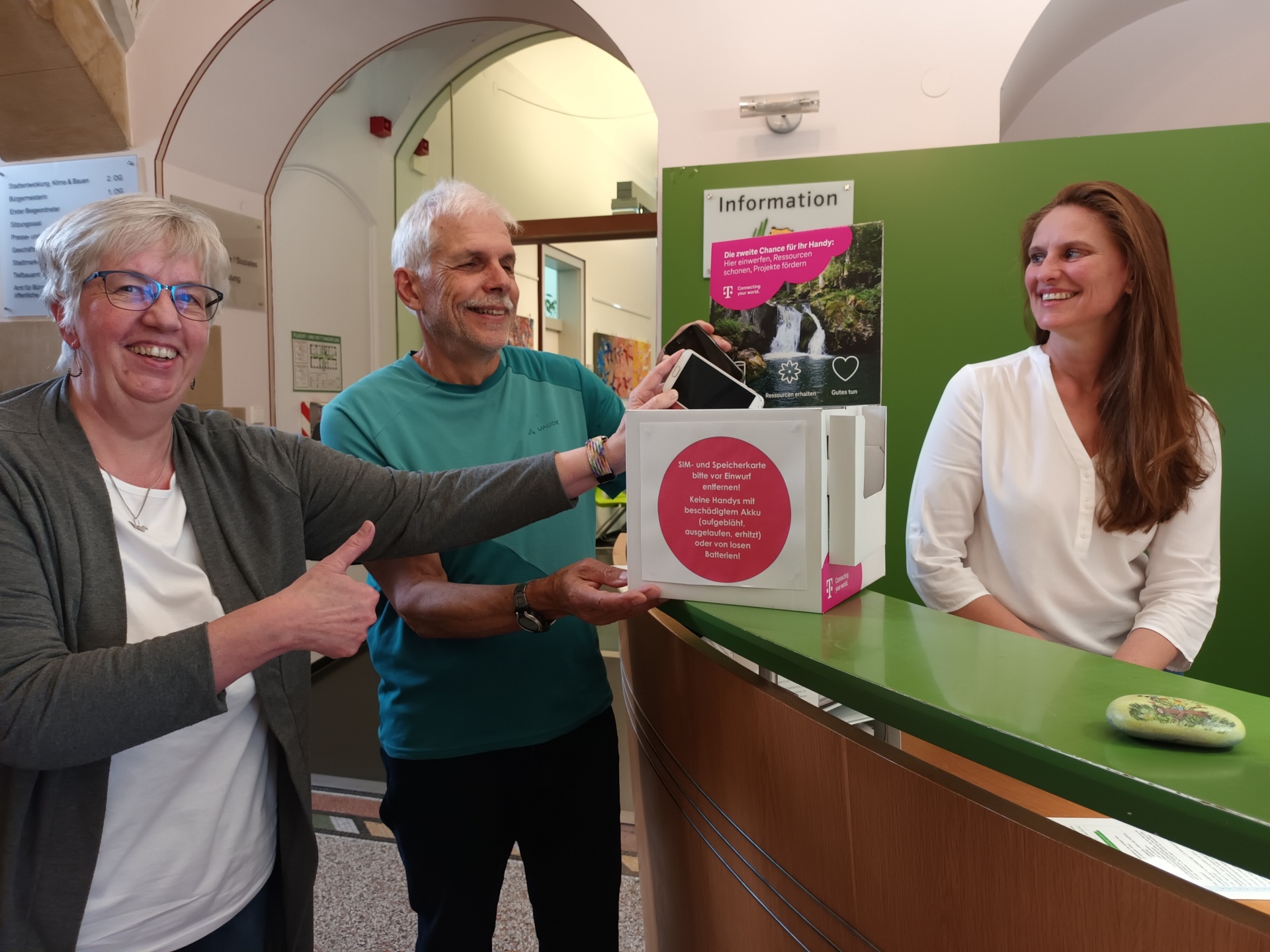 Marion Schodt und Erich Schoepe vom Technikcafe sowie Susanne Schmid von der Stadt Tettnang freuen sich über die neue Box, die ab sofort im Rathaus alte Handys sammelt