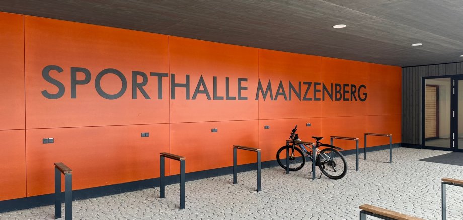 Eingangsbereich der Sporthalle Manzenberg mit Fahrradständern und einem abgestellten Fahrrad