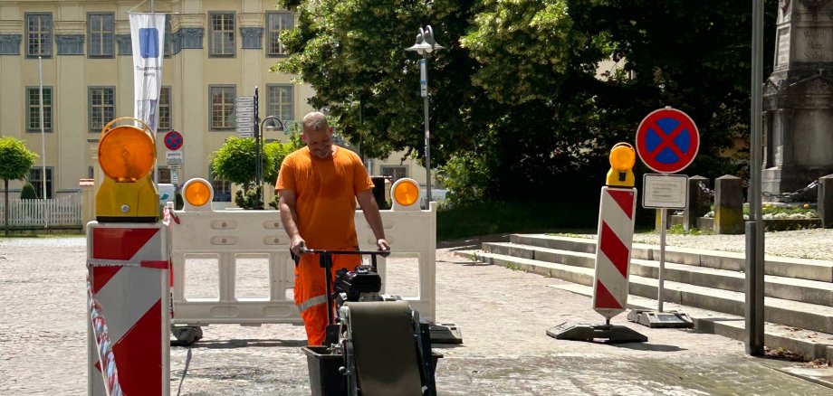 Mitarbeiter des Bauhofs verfugt Pflaster in der Montfortstraße mit einer Pflasterausfugmaschine