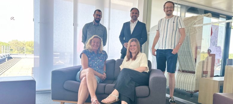 Ein Teil des Teams des neuen Amtes Digitalisierung & IT (auf dem Bild sind Beatrix Arnold und Fanny Frohberg auf einer Bank sitzend, dahinter Mike Hengge, Amtsleiter Serkan Parlak und Fabian Döbber)