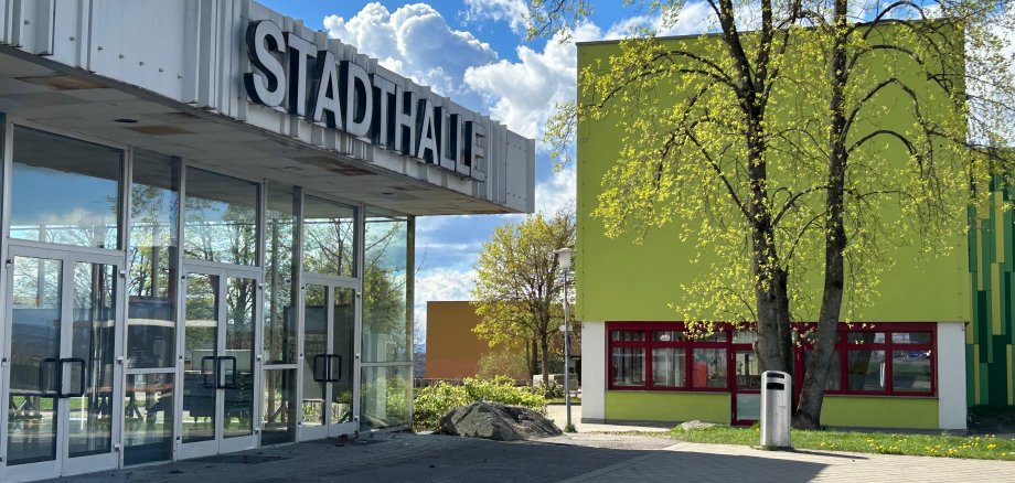 Eingang Stadthalle mit Schulgebäude im Hintergrund
