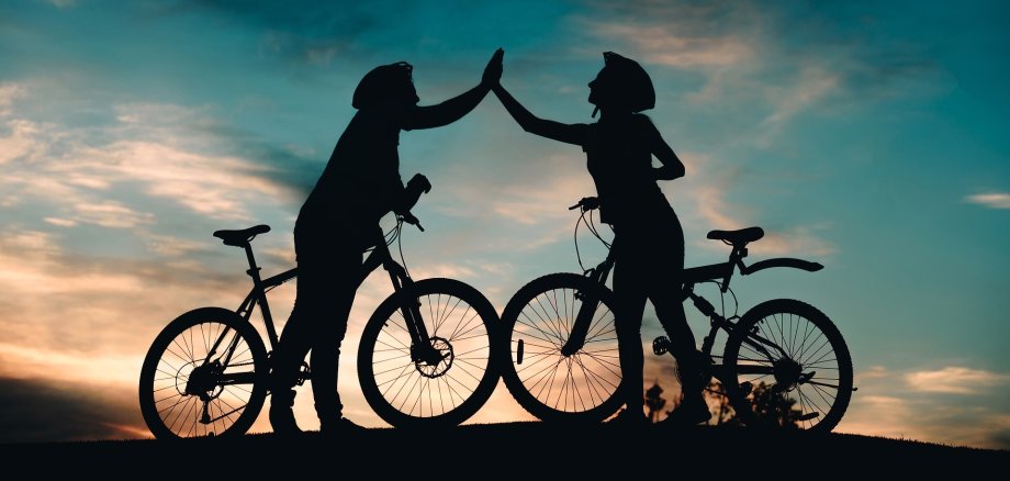 Zwei Radfahrer, die sich "high five" geben