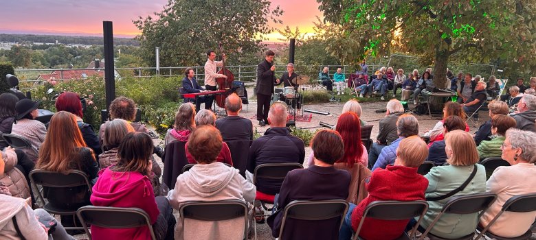 Ansicht auf Sänger und Band Summernight Swing feat. Kilian Sladek und Besucher im Sonnenuntergang