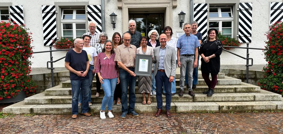 Die Teilnehmenden der Rezertifizierungsveranstaltung vor demRathaus mit der Urkunde Fairtrade Town