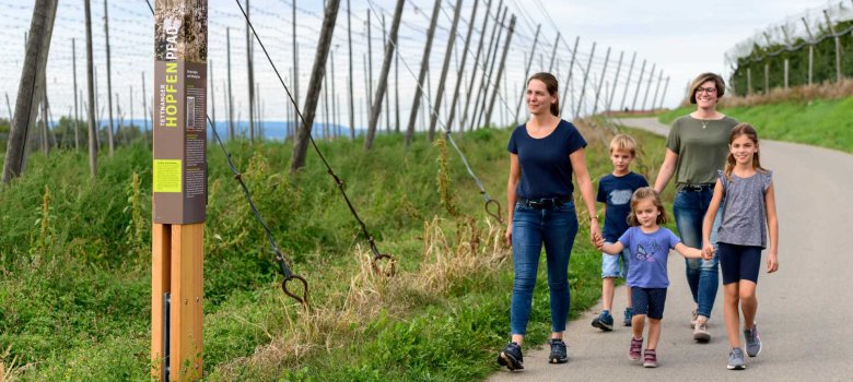 Zwei Frauen und drei Kinder wandern auf dem Hopfenpfad