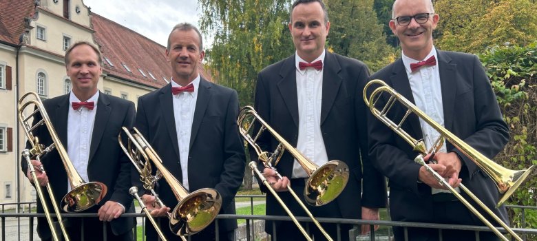 Die vier Posaunisten des Quartetts Tromposi mit ihren Instrumenten