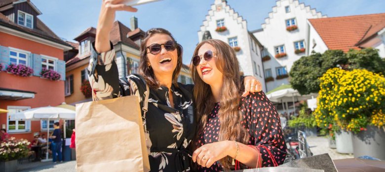 Zwei junge Frauen mit Einkaufstaschen machen ein Selfie auf dem Bärenplatz