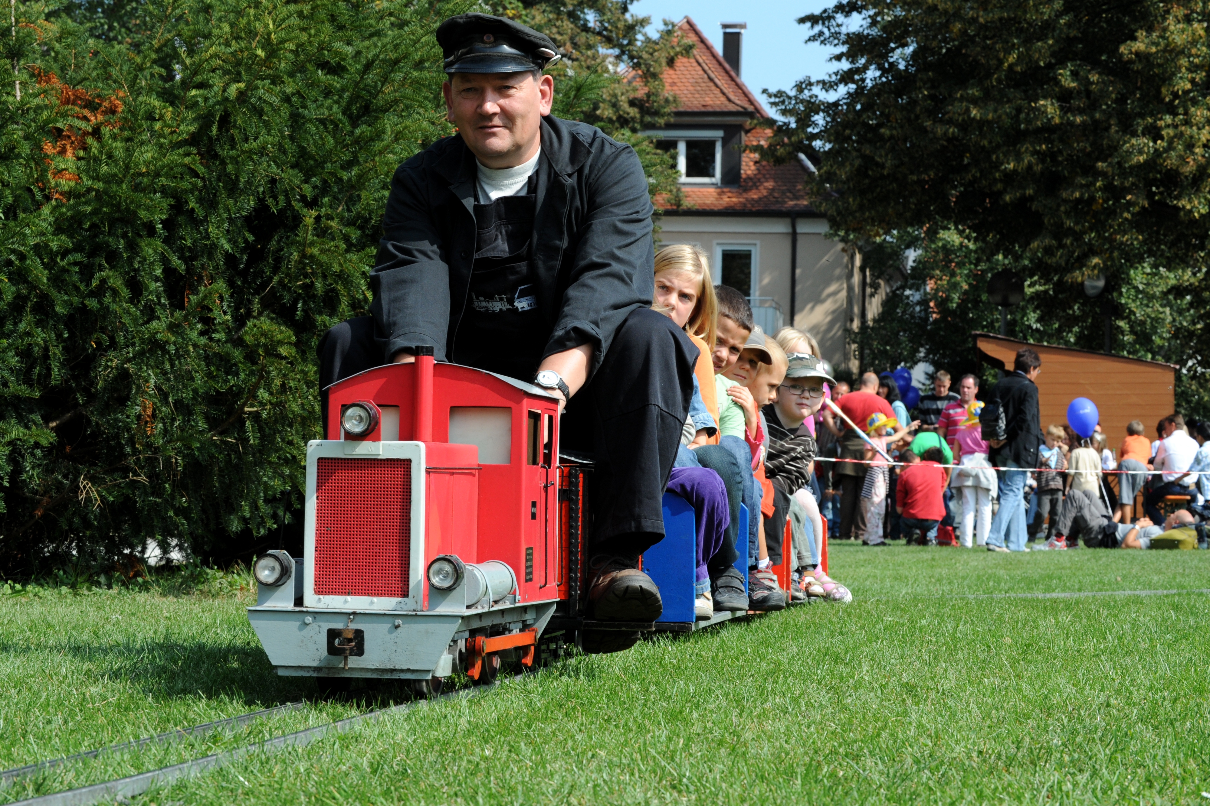 Kindereisenbahn mit Lokführer und Kindern unterwegs beim Bähnlesfest