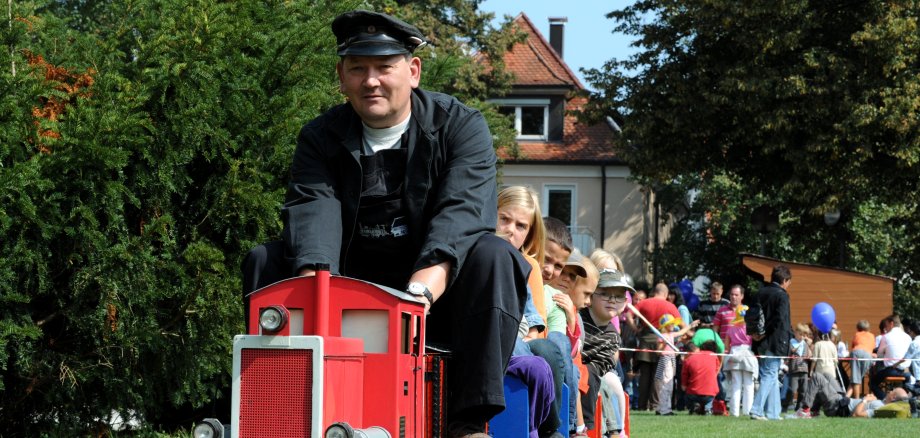 Kindereisenbahn mit Lokführer und Kindern unterwegs beim Bähnlesfest
